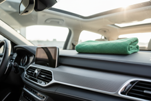 Load image into Gallery viewer, green towel on interior dash of a car

